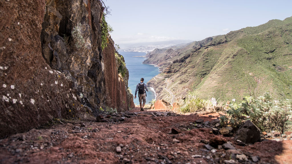 Persona caminando por sendero hacia el mar en el Parque Rural de Anaga, Tenerife.
