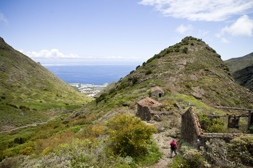 Valle montañoso con ruinas y vista al mar en Tenerife.