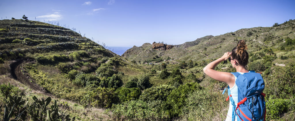 Persona con mochila observa paisaje montañoso en Tenerife.