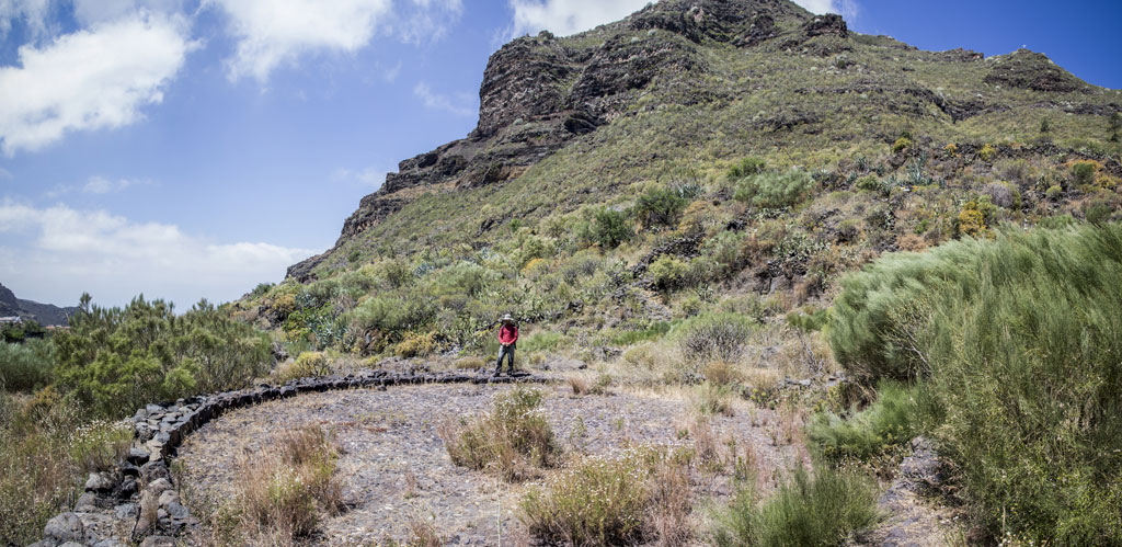 Sendero en montaña del Parque Rural de Teno, Tenerife, con caminante solitario.