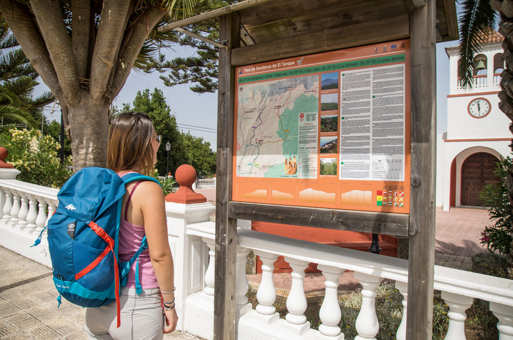 Mujer observando cartel de senderos en El Tanque, Tenerife.