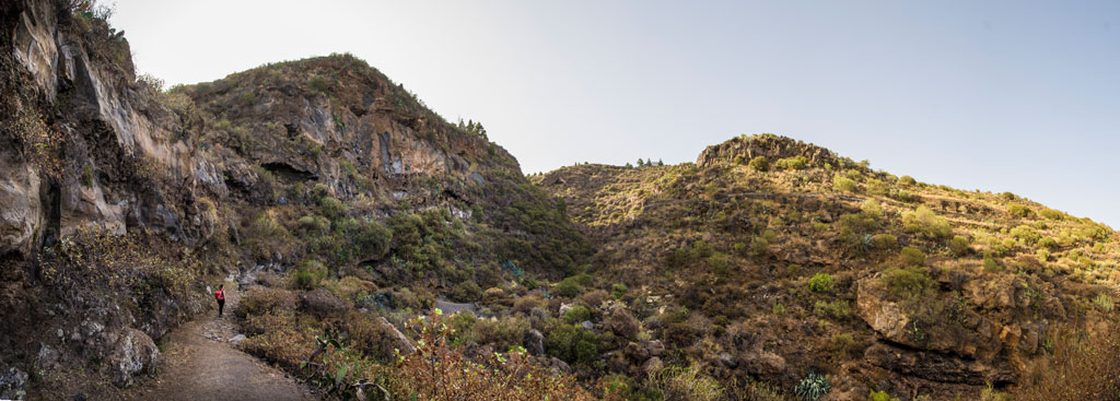 Sendero con colinas rocosas y vegetación en un paisaje de Tenerife.