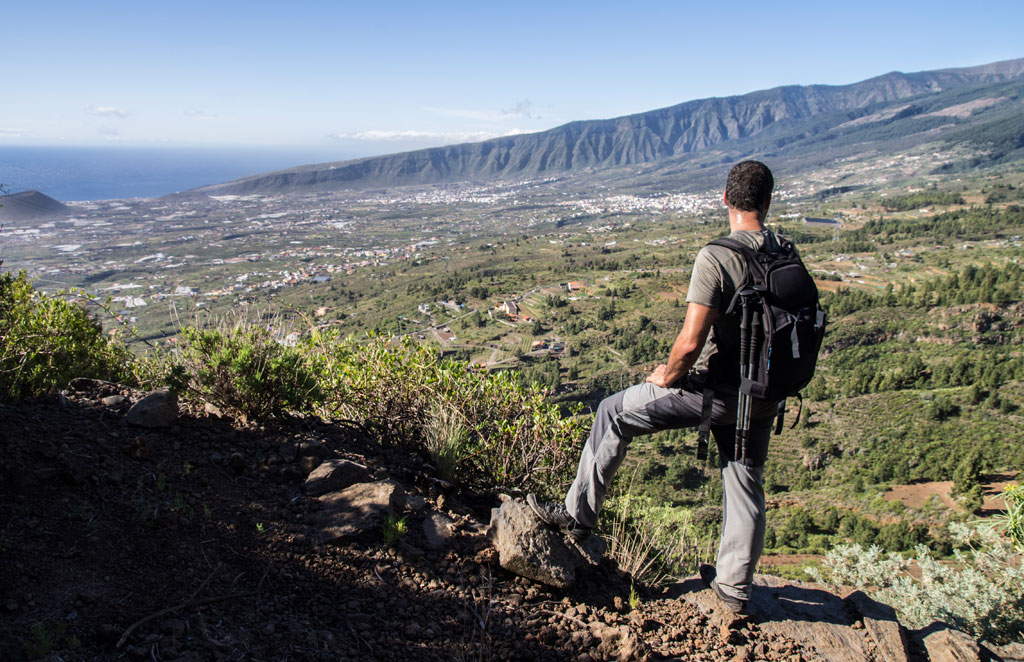 Persona con mochila observando el paisaje montañoso de Tenerife desde un mirador.