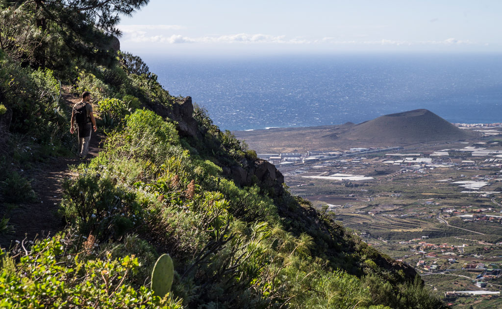Sendero con caminante y vista del paisaje en Tenerife hacia el mar.