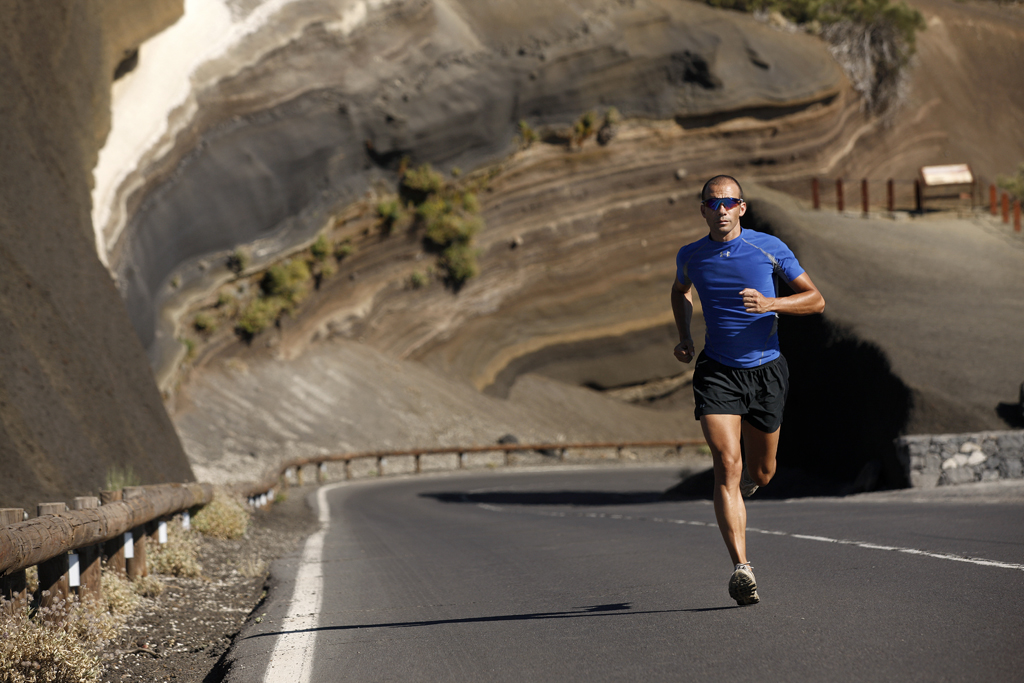 Corredor con camiseta azul en carretera de montaña en Tenerife.