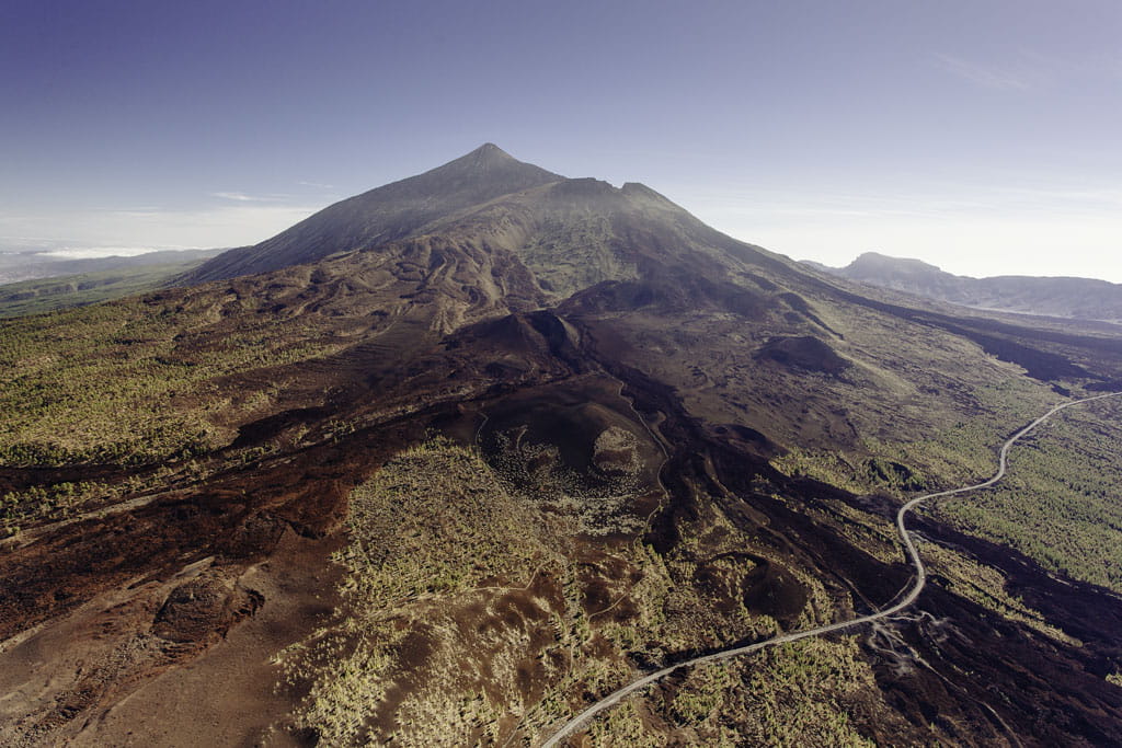 Vista aérea del Teide en Tenerife con un paisaje volcánico y una carretera.