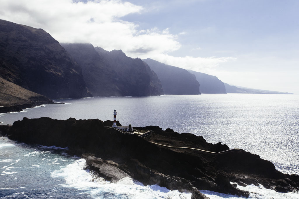 Faro de Punta de Teno en Tenerife junto a acantilados y el océano Atlántico.