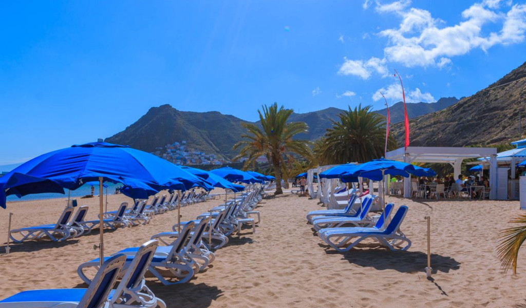 Tumbonas y sombrillas azules en la playa de Las Teresitas en Tenerife.