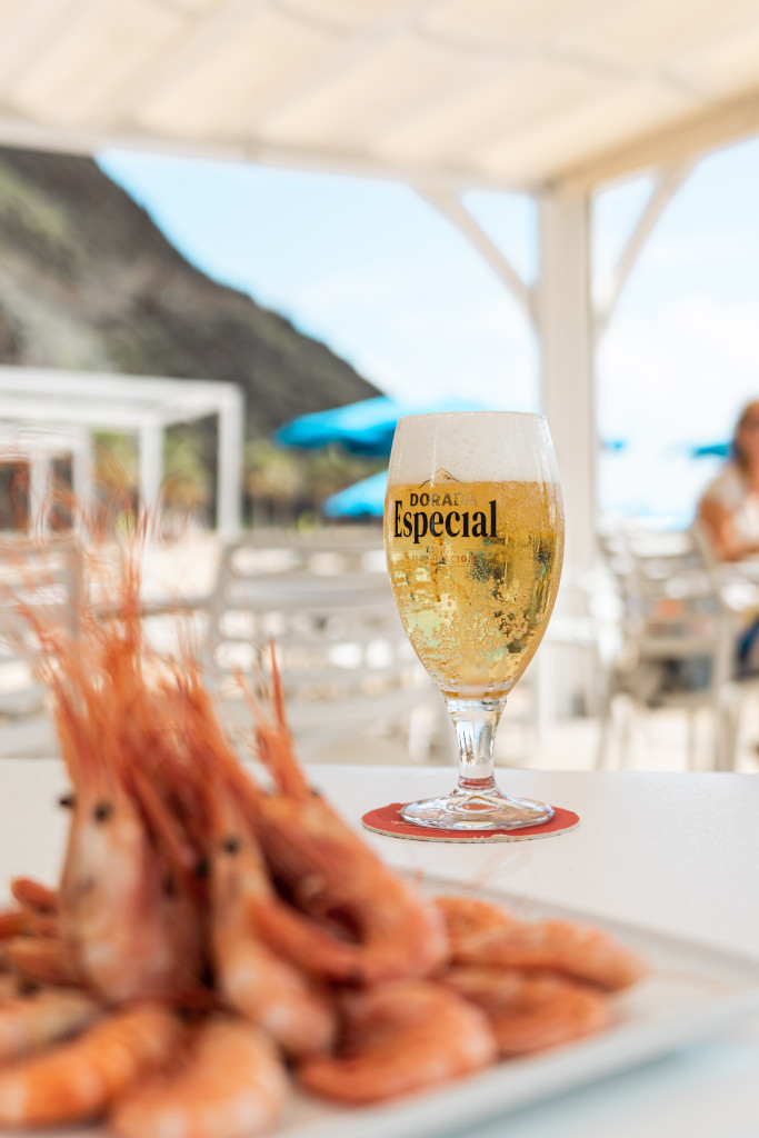 Vaso de cerveza Dorada Especial junto a gambas en terraza en Tenerife.