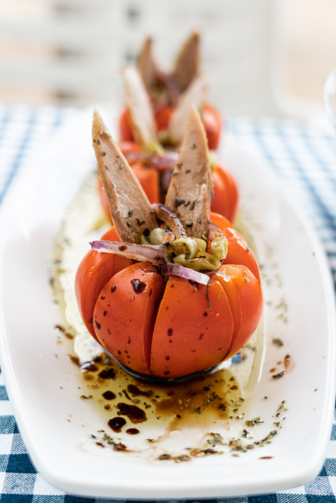 Tomates rellenos con atún y cebolla sobre plato blanco en mesa de Tenerife.