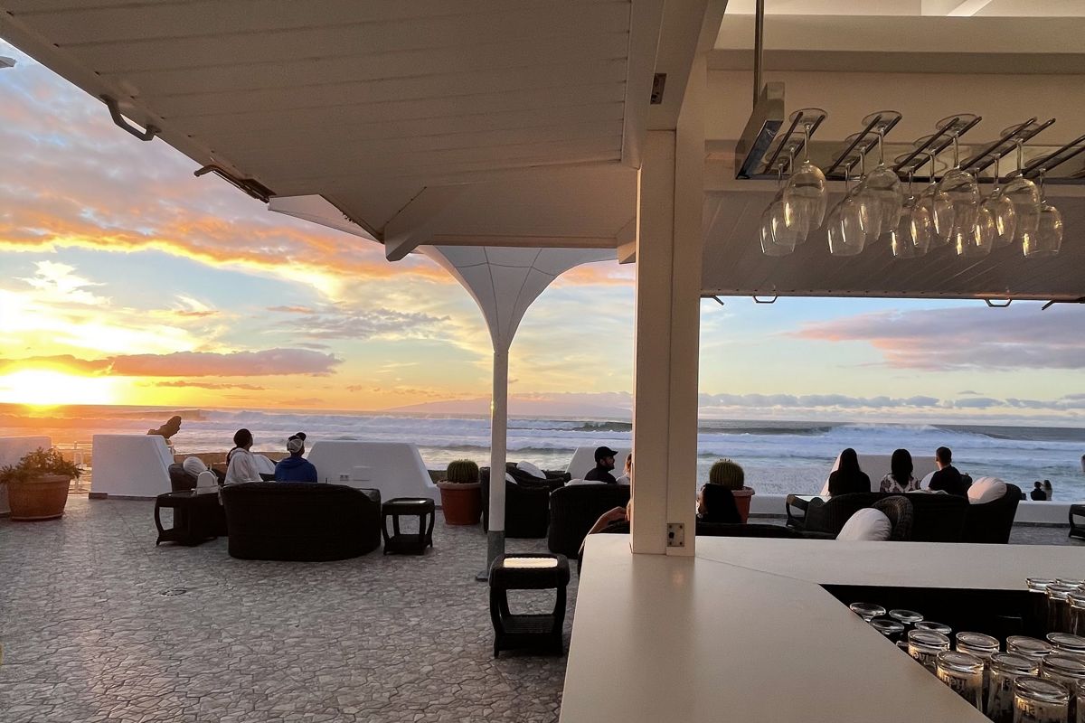 Terraza en Tenerife con personas mirando el atardecer sobre el mar.