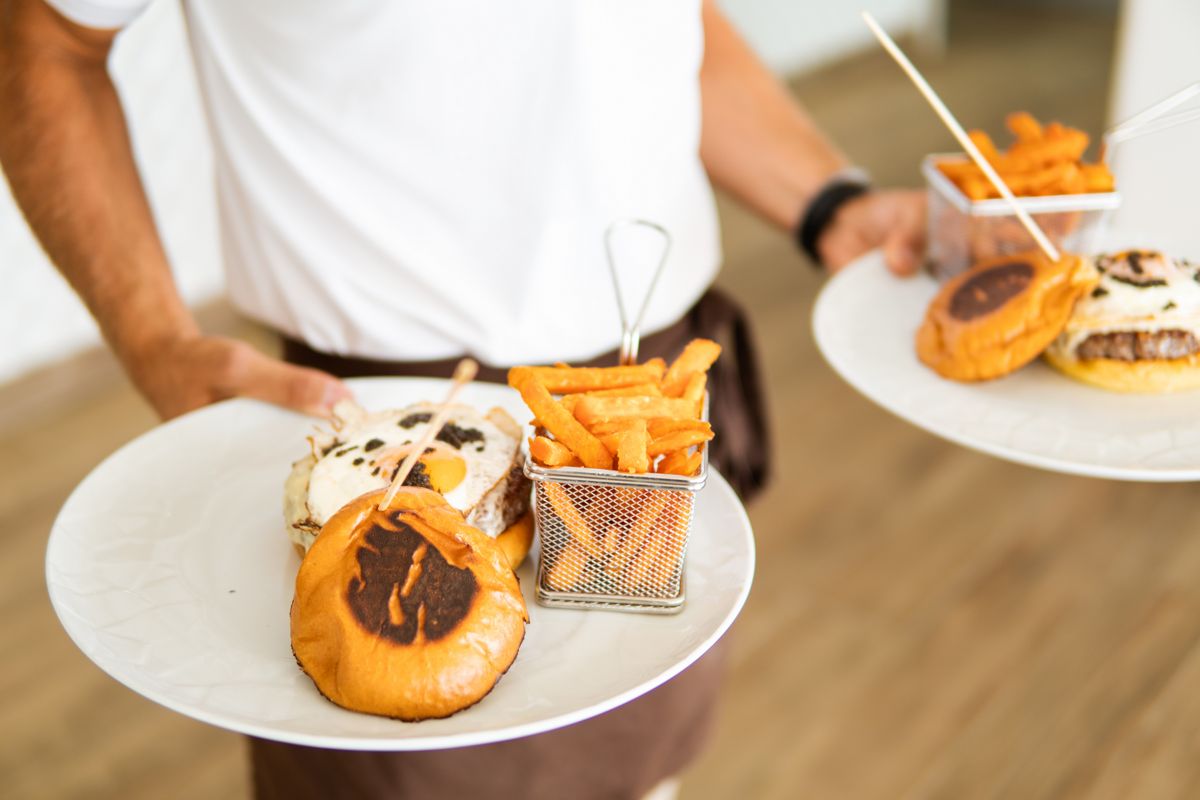 Platos de hamburguesas con papas fritas servidos en Tenerife.