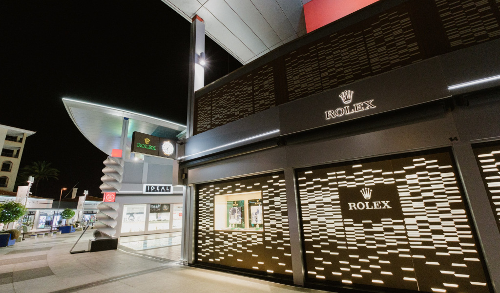 Tienda Rolex iluminada de noche en un centro comercial de Tenerife.