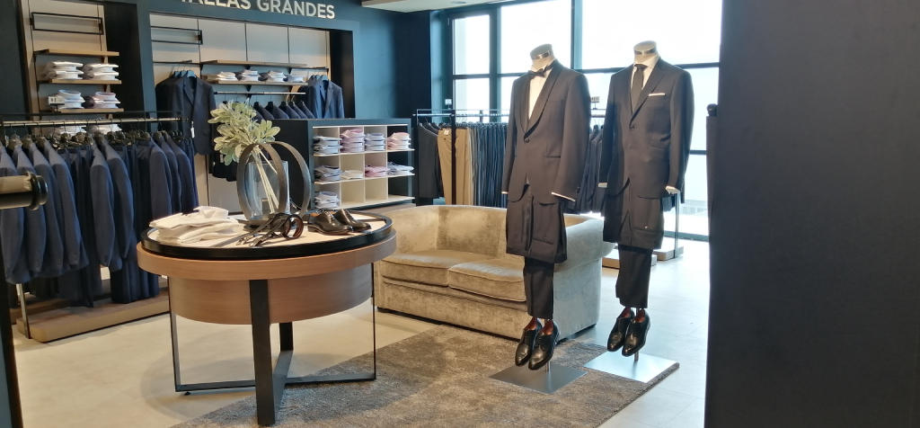 Trajes en exhibición en tienda de moda en Tenerife. Tallas Grandes visible arriba.