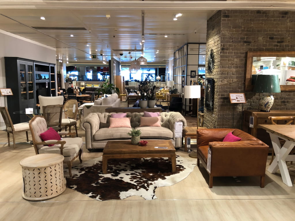 Muebles de sala en un salón de exposición en Tenerife con sofá y sillones.