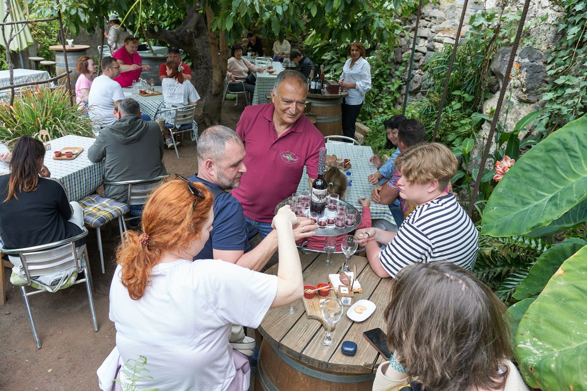 Personas compartiendo bebidas en terraza de restaurante en Tenerife.