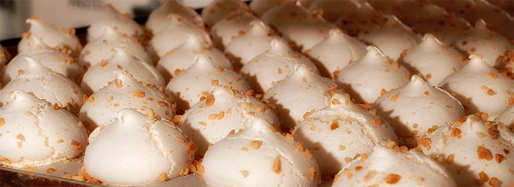Merengues con almendra sobre una bandeja en pastelería de Tenerife.
