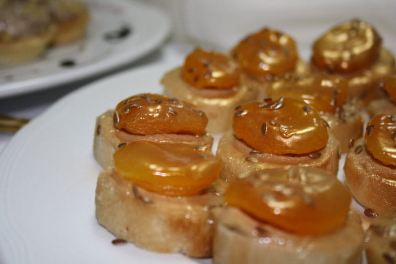 Rodajas de pan con albaricoques caramelizados y semillas en un plato blanco, Tenerife.