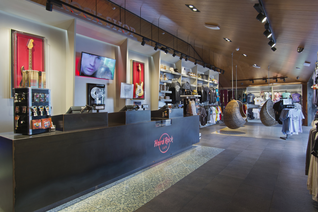 Tienda de regalos dentro del Hard Rock Café en Tenerife, con guitarras y ropa expuesta.