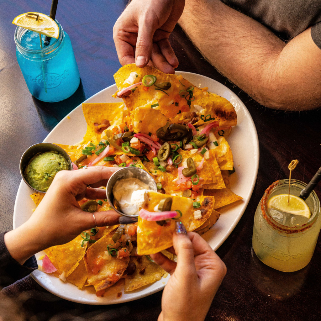 Nachos con guacamole y crema agria en restaurante de Tenerife, acompañados de bebidas.