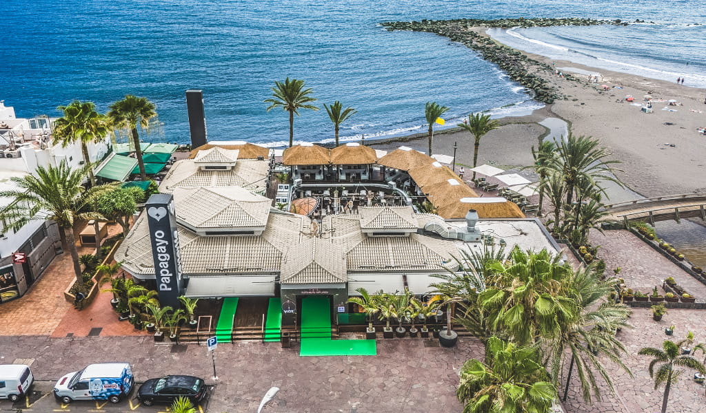 Vista aérea de un restaurante costero en Tenerife junto a la playa y el océano.