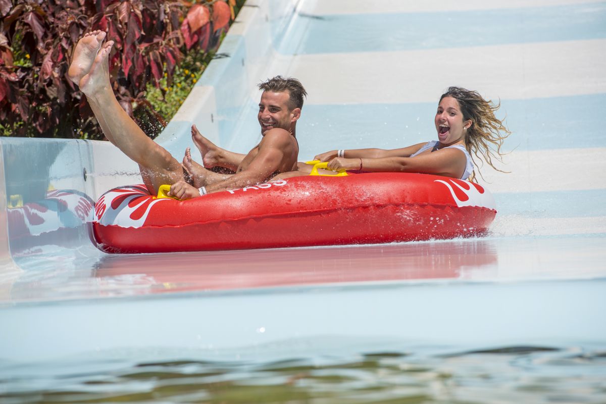 Personas disfrutando en una colchoneta en tobogán acuático en Tenerife.