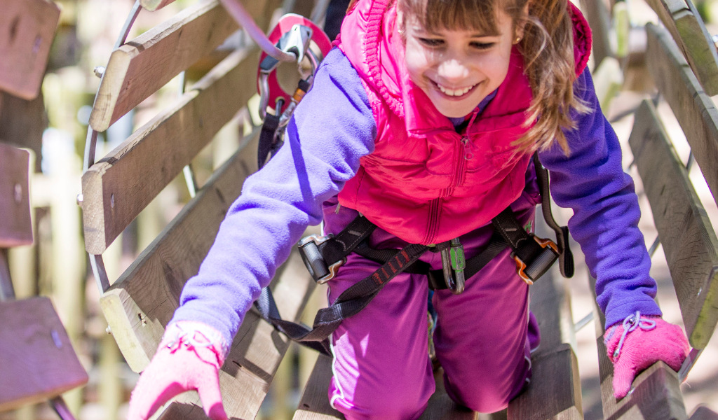 Niña trepando en parque de aventuras en Tenerife.