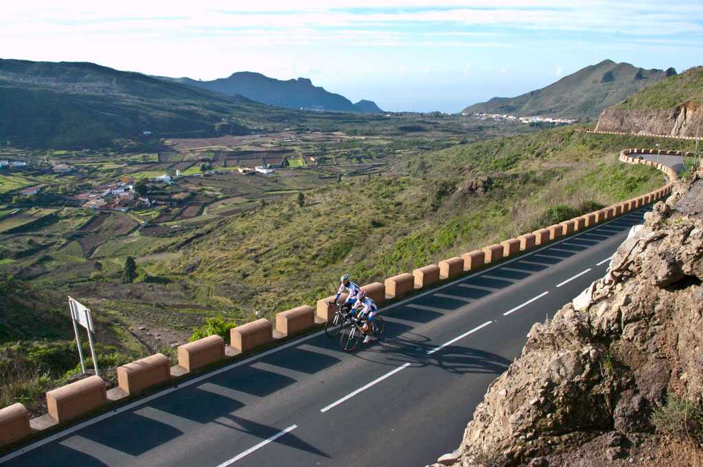 Ciclistas en carretera serpenteante en el paisaje montañoso de Tenerife.