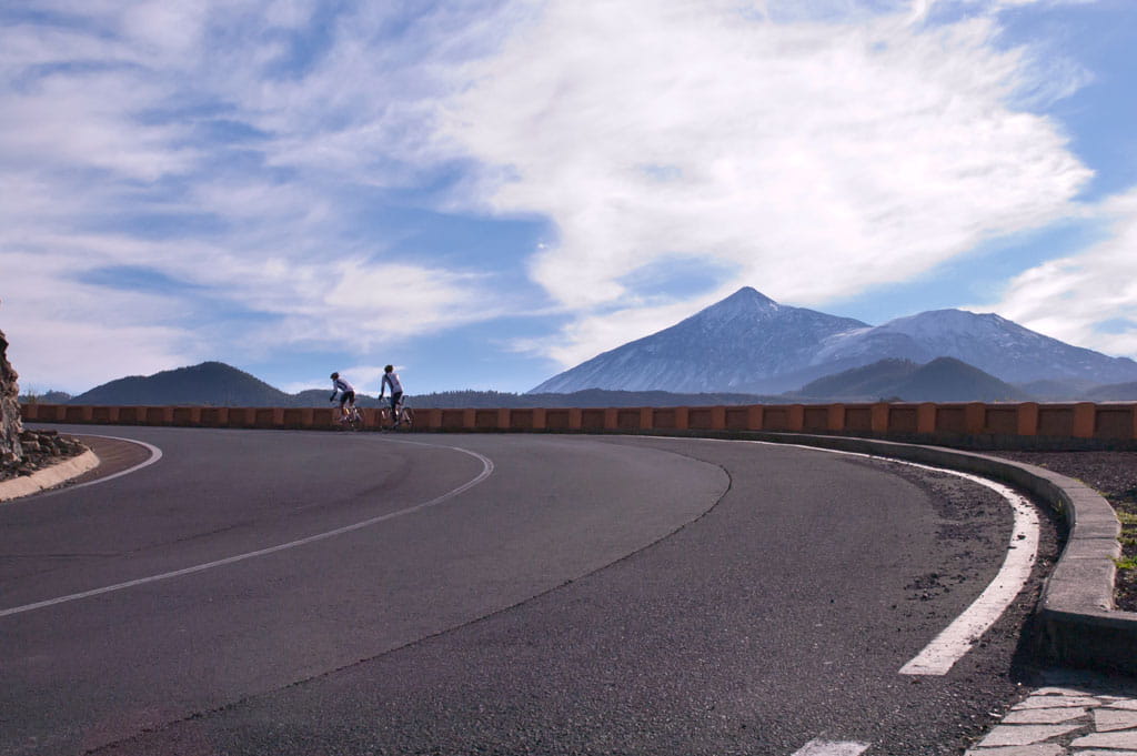 Ciclistas recorren carretera con vistas al Teide en Tenerife.