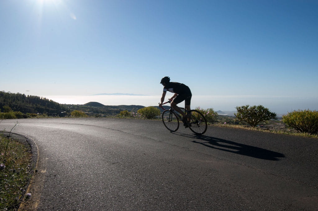 Ciclista descendiendo por carretera con vistas en Tenerife.