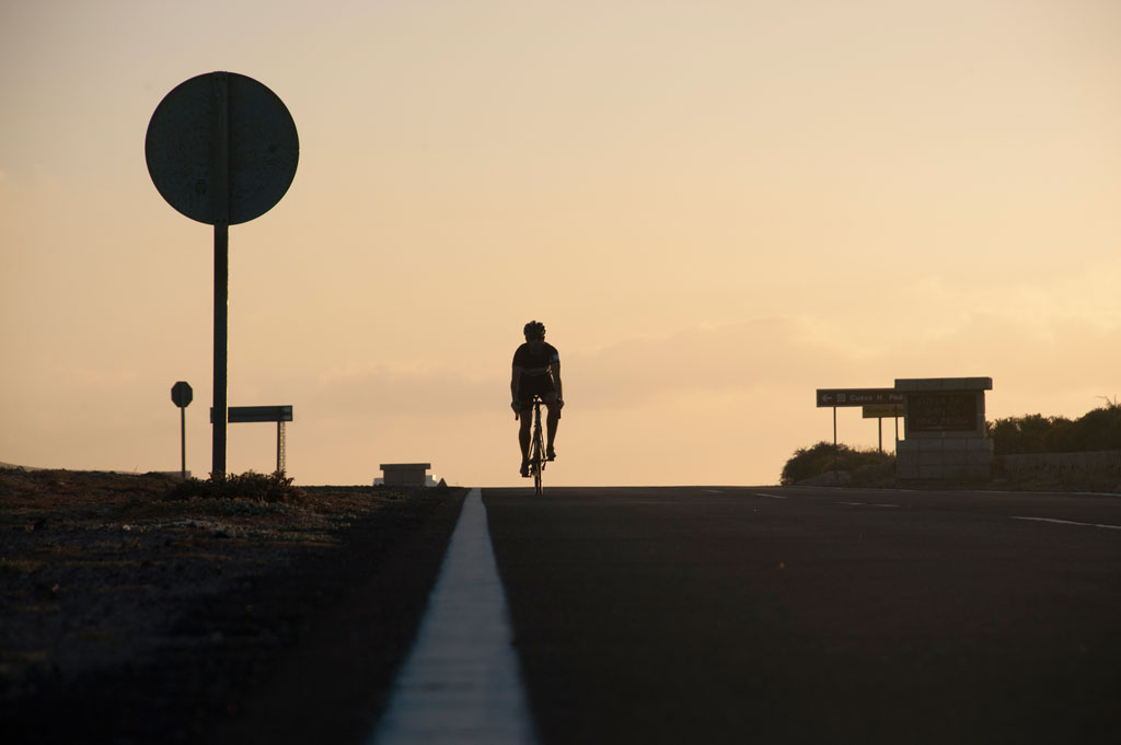 Ciclista en carretera al atardecer en Tenerife.