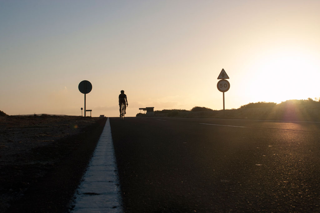 Ciclista al atardecer en carretera de Tenerife con límite de 50.