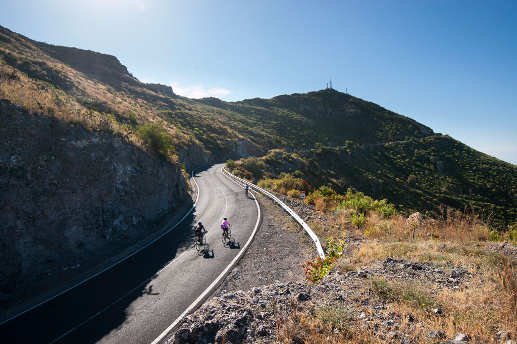 Ciclistas ascendiendo una carretera montañosa en Tenerife.