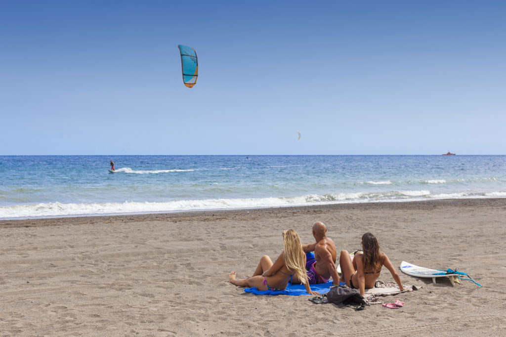 Personas observando a un kitesurfista en la playa de El Médano, Tenerife.