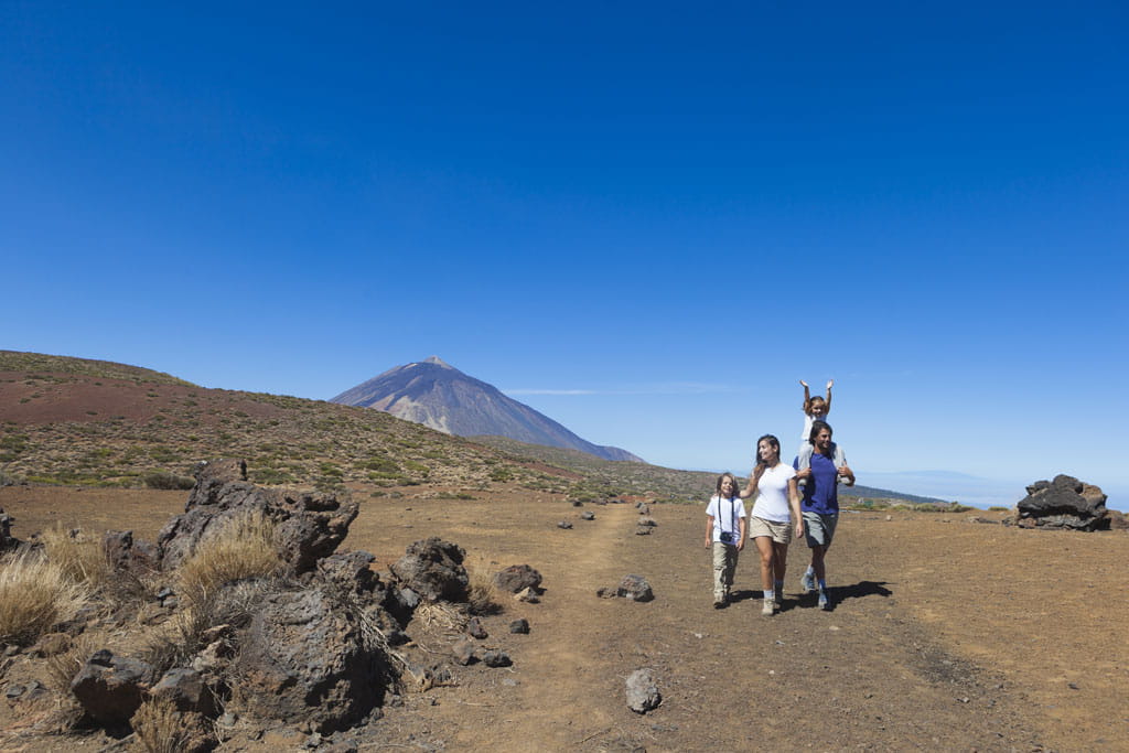 Familia caminando por paisaje volcánico del Teide, Tenerife.