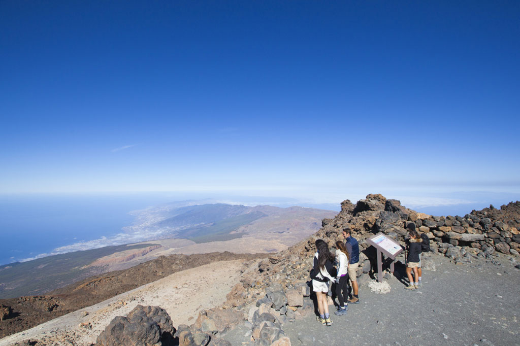 Personas observan paisaje desde mirador en Parque Nacional del Teide, Tenerife.