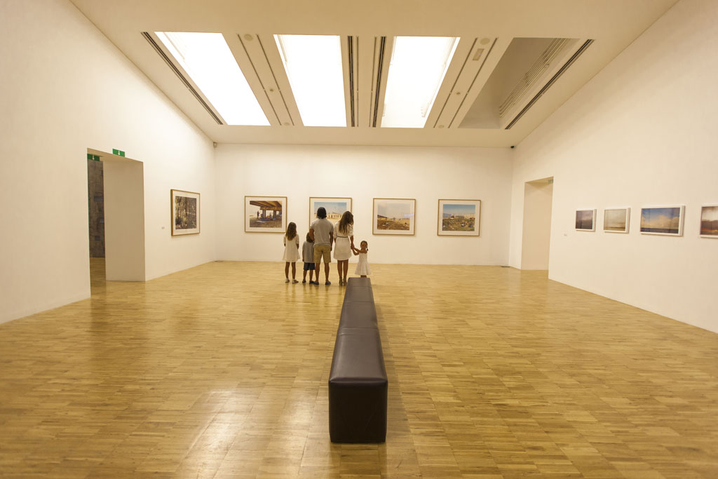 Familia observando pinturas en una galería de arte en Santa Cruz de Tenerife.