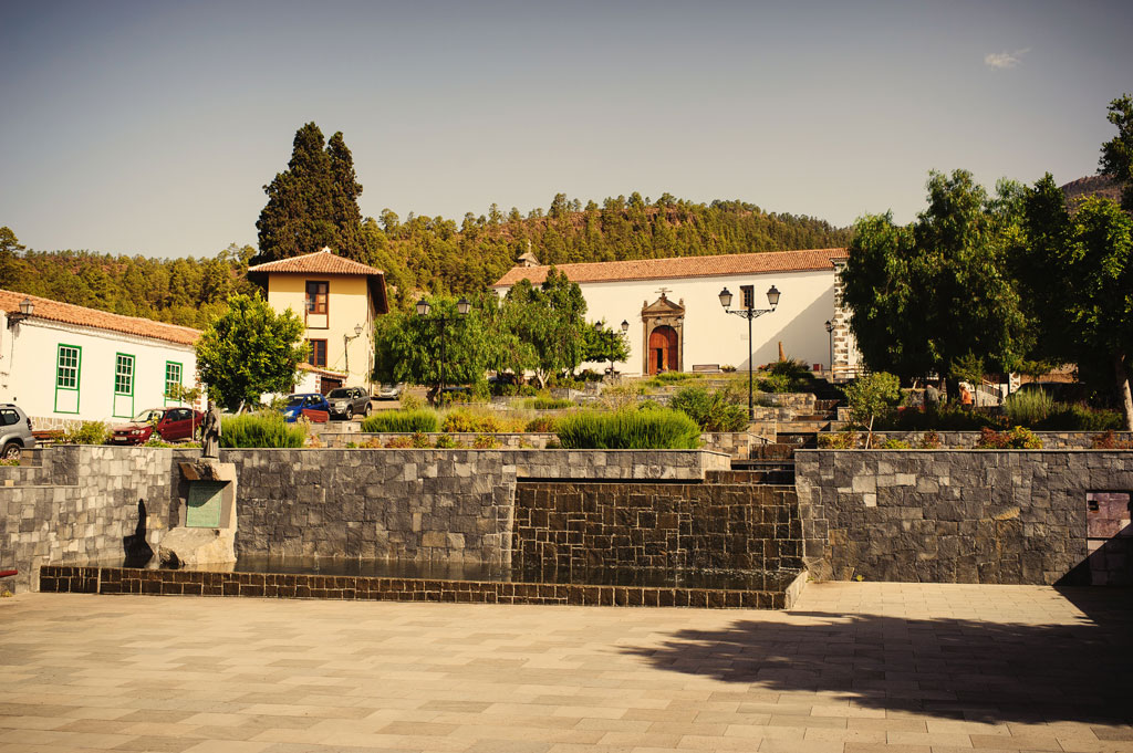 Plaza con árboles y edificios históricos en Vilaflor, Tenerife.