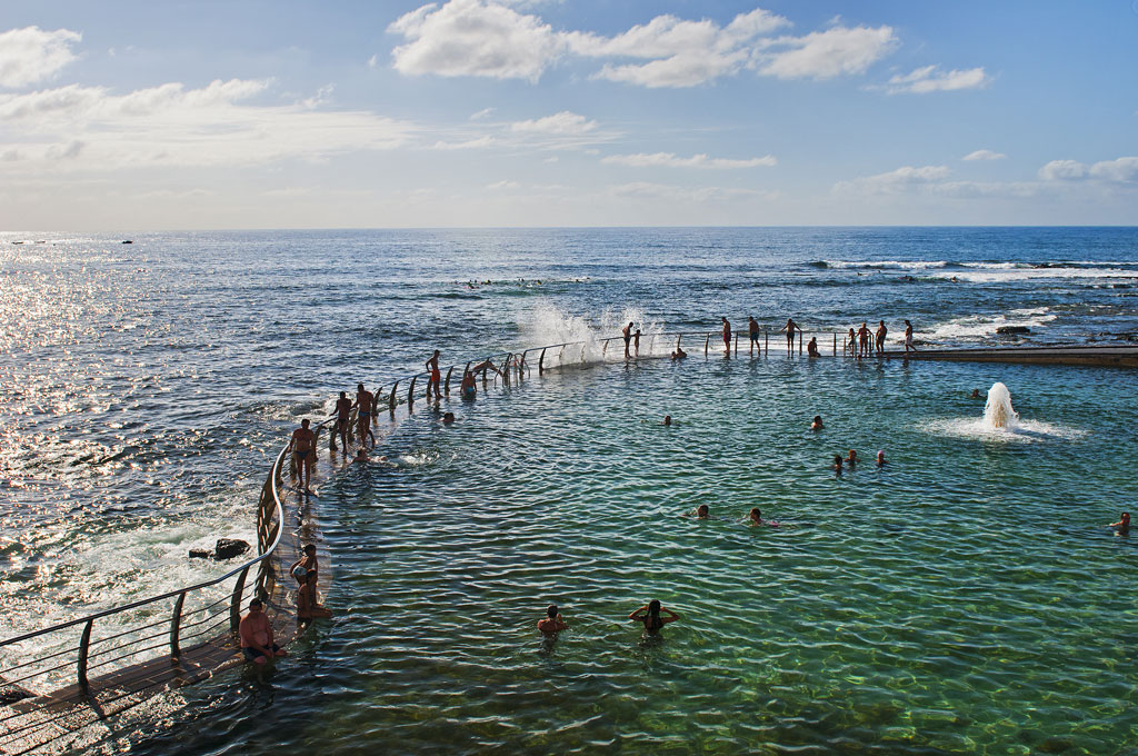 Personas nadan en una piscina natural junto al mar en Tenerife.