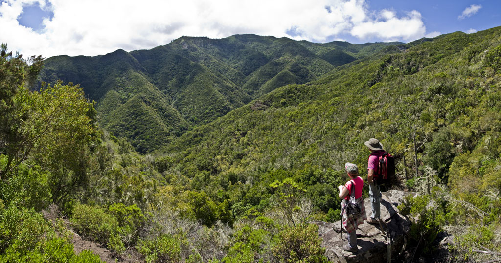 Dos excursionistas observan el paisaje montañoso en Anaga, Tenerife.