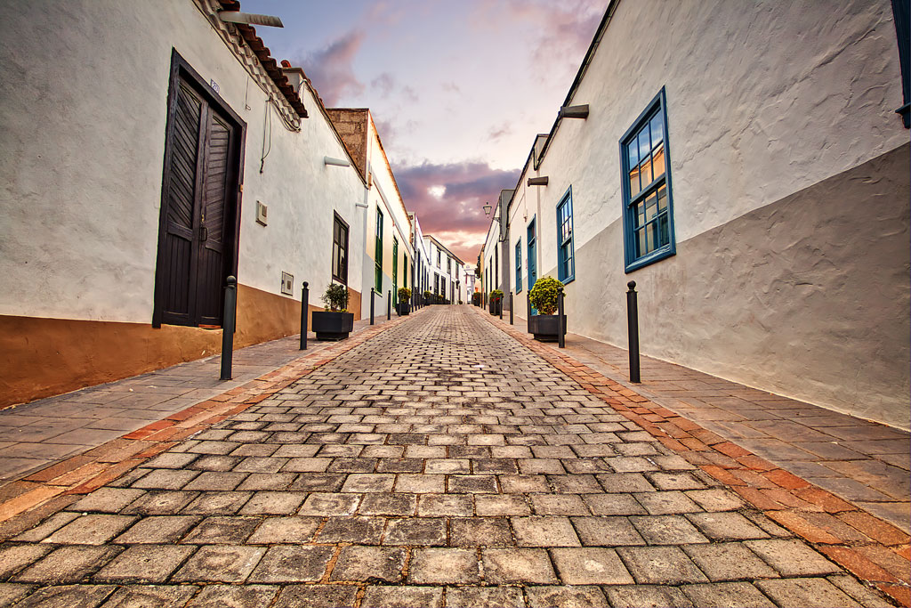 Calle adoquinada con casas tradicionales en La Laguna, Tenerife, al atardecer.