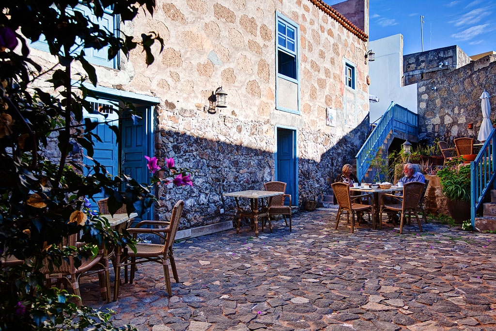 Patio empedrado con mesas y sillas al aire libre en un restaurante de Tenerife.