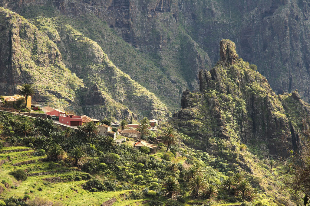 Pueblo de Masca en Tenerife rodeado de montañas verdes y casas dispersas.