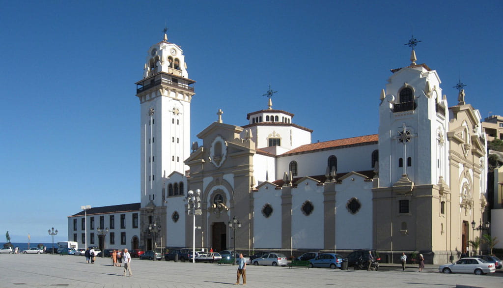 Basílica de la Candelaria en Tenerife con cielo despejado y personas alrededor.