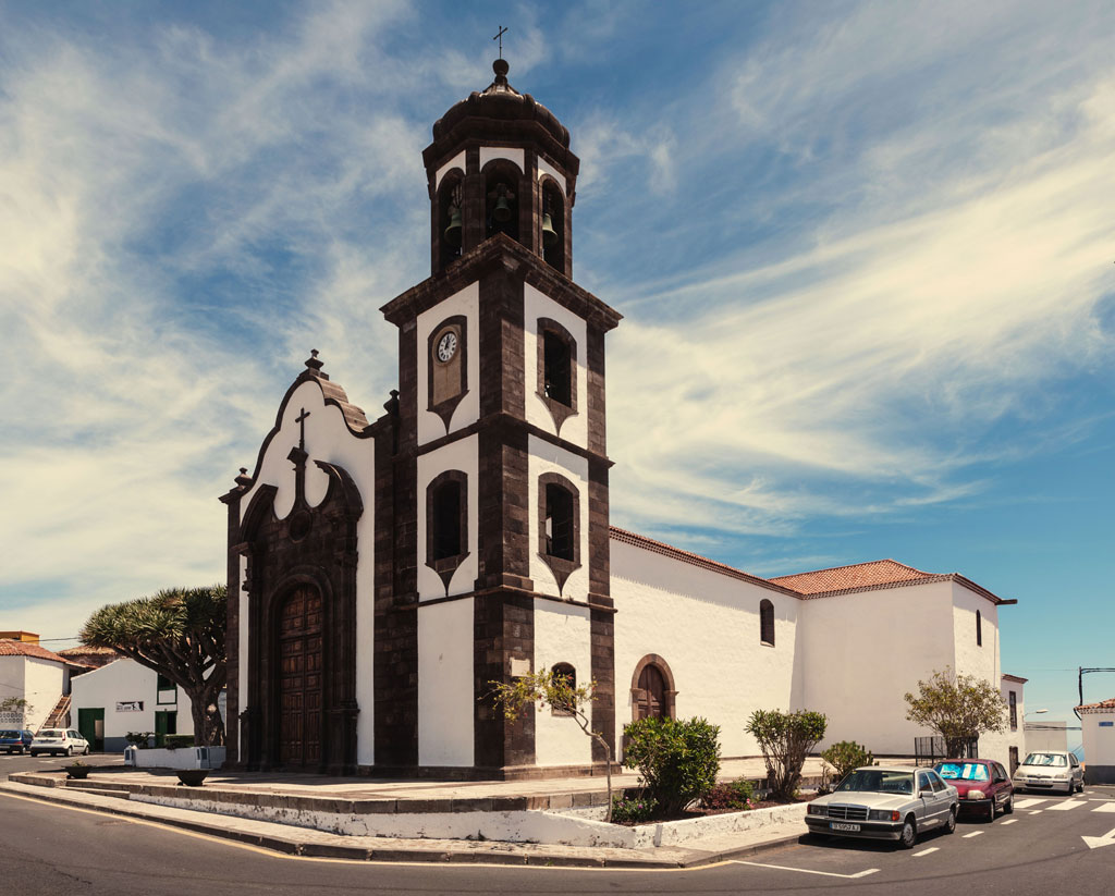 Iglesia en Garachico, Tenerife, con cielo despejado y árboles alrededor.