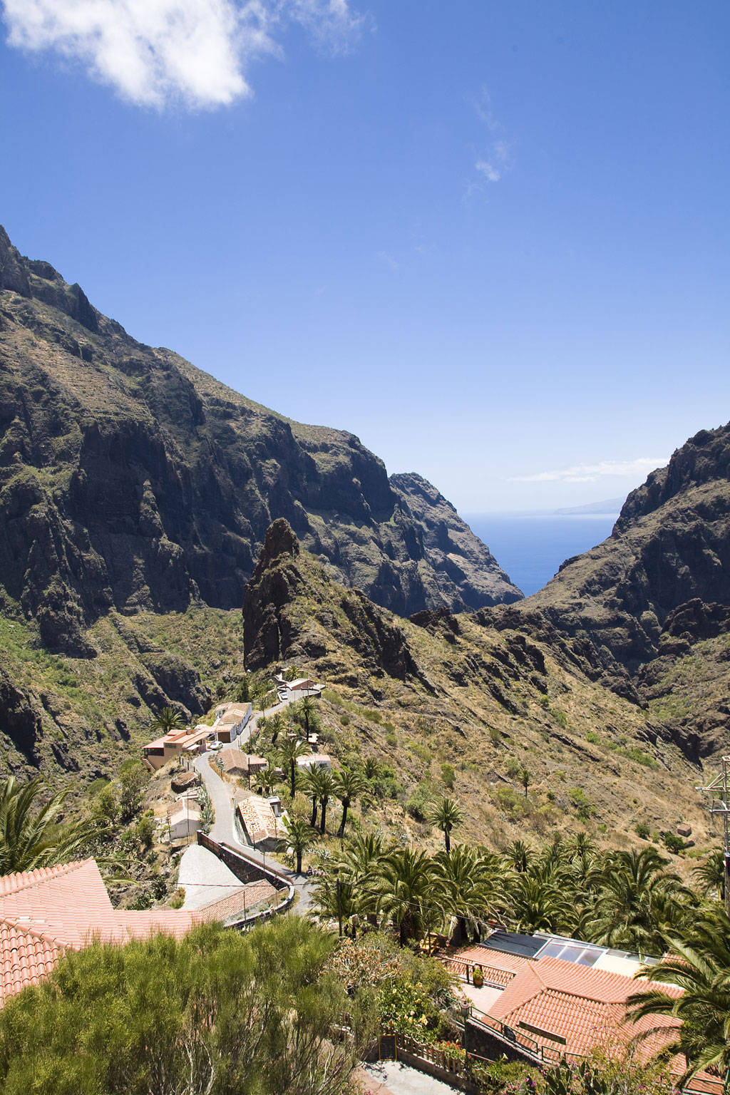 Valle y casas en el barranco de Masca, Tenerife, con el océano al fondo.
