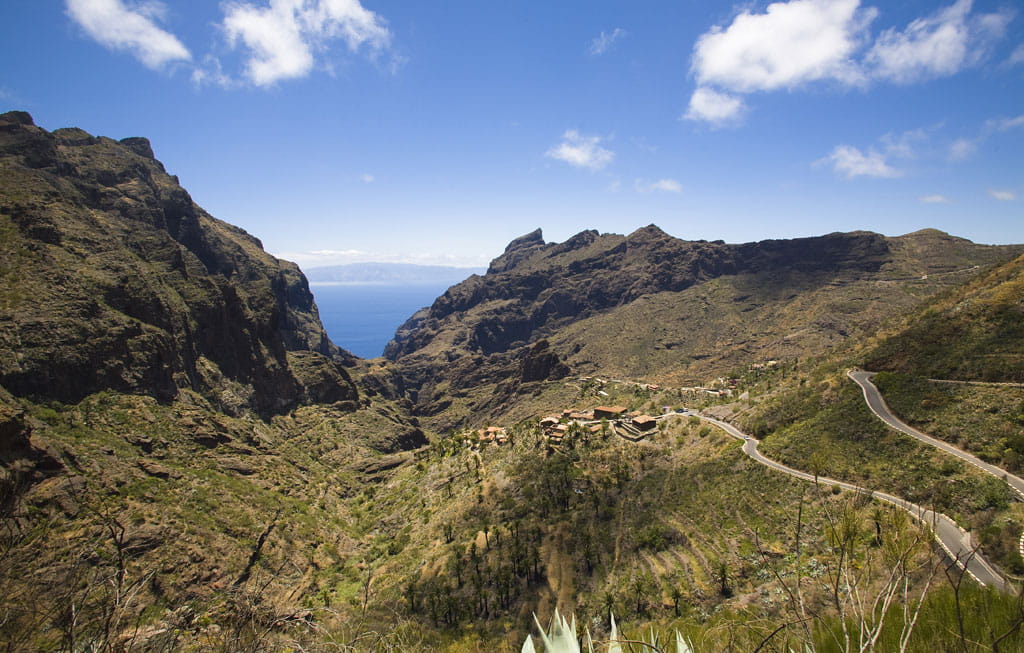 Vista del barranco de Masca en Tenerife con carretera serpenteante y montañas.