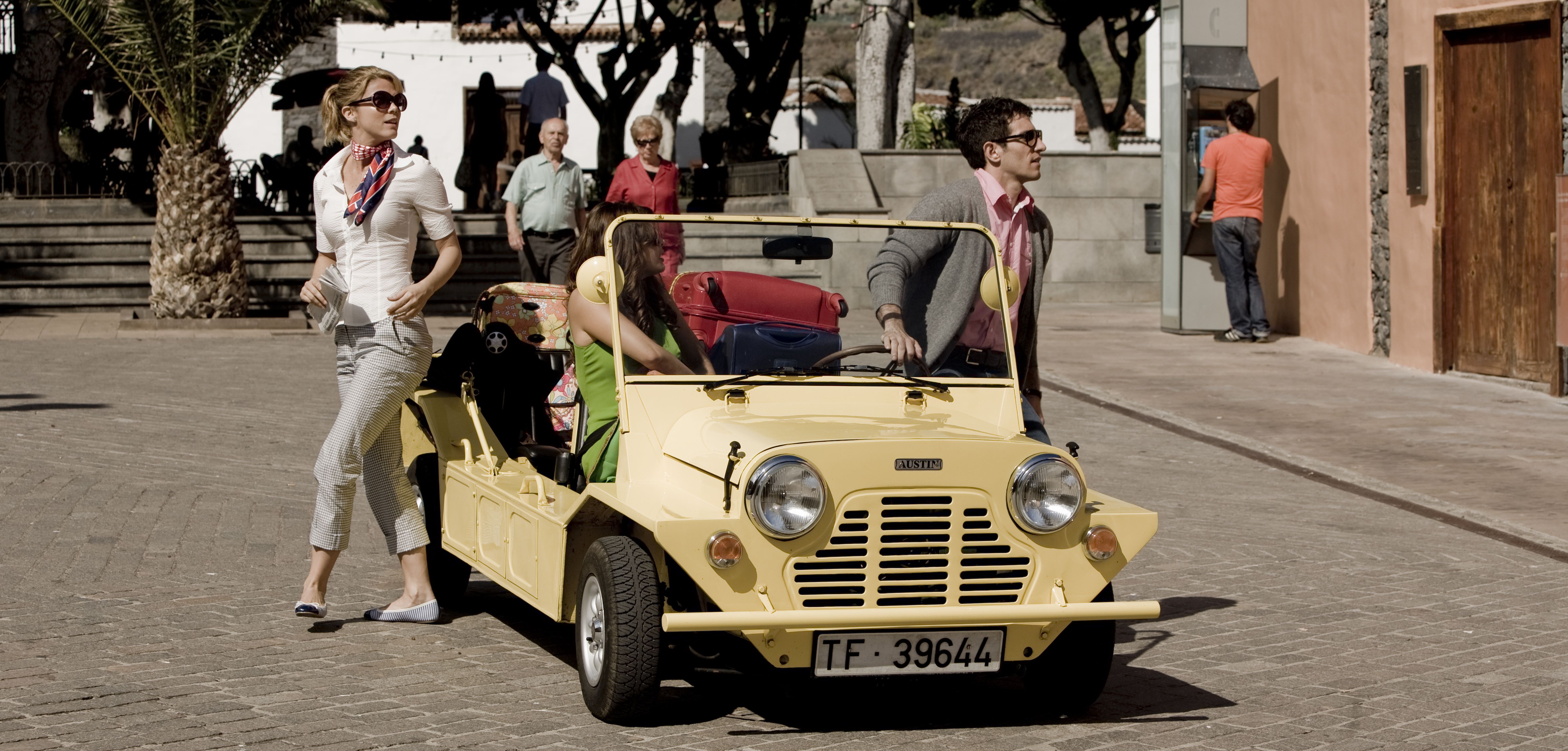 Mujer y hombre junto a coche amarillo descapotable en Tenerife.