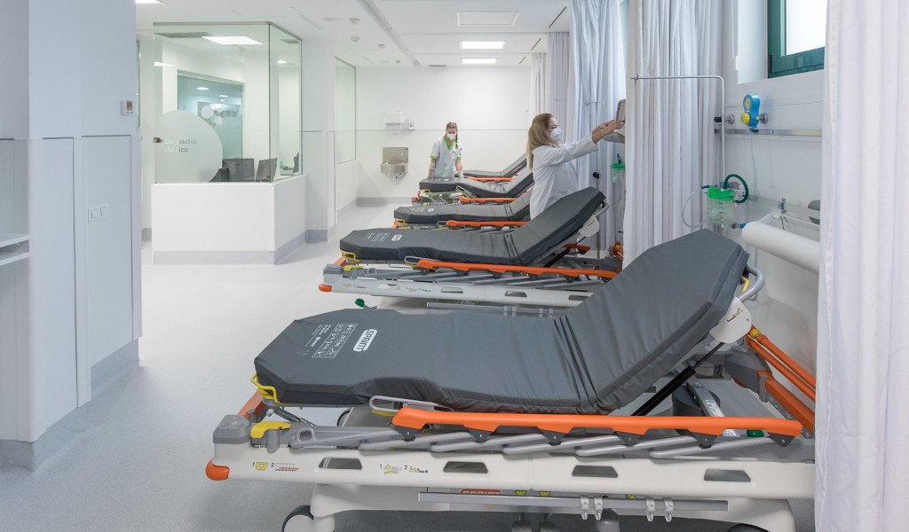 Camas de hospital en fila con personal médico ajustando equipo en Santa Cruz de Tenerife.