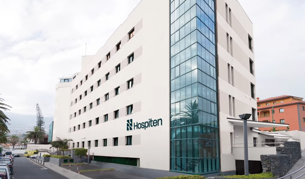 Edificio del hospital Hospiten en Tenerife con fachada blanca y ventanas grandes.